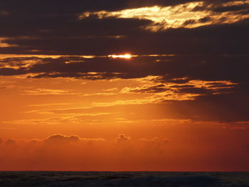 Scenic view of sea against orange sky