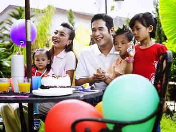 Family celebrating birthday in lawn