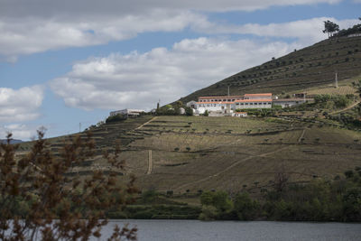 Buildings on mountain against cloudy sky