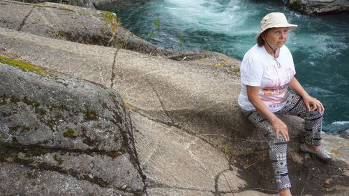 Full length of woman standing on rock at shore