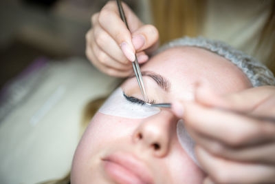 Cropped hand of woman applying eye patch