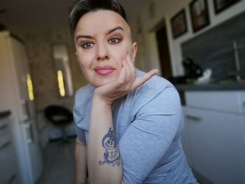 Close-up of thoughtful woman with raised eyebrows at home 