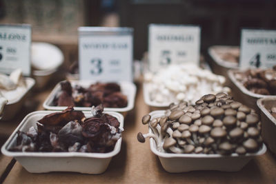 Close-up of edible mushrooms with various food arranged at store for sale