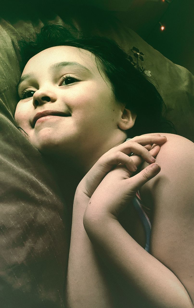 real people, one person, portrait, indoors, lifestyles, child, headshot, childhood, lying down, leisure activity, close-up, toddler, smiling, cute, young adult, front view, hand, innocence