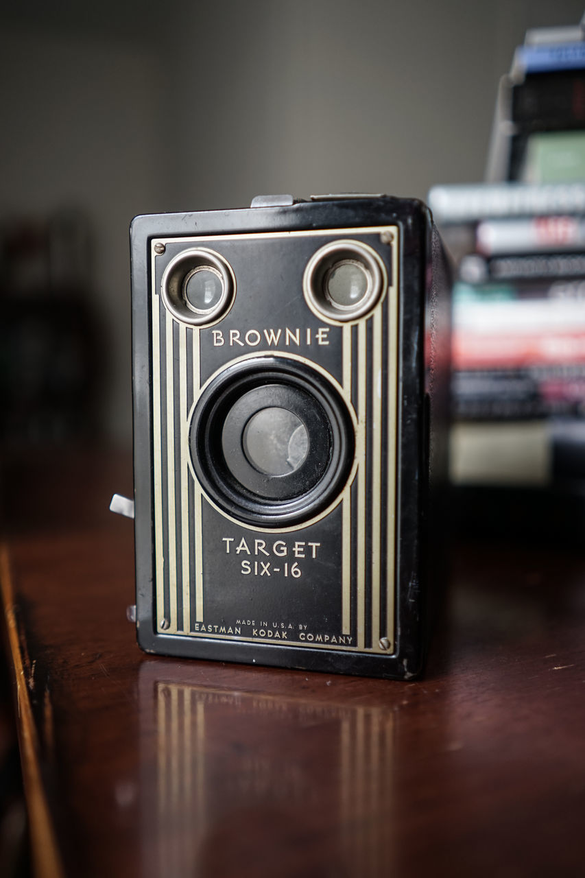 CLOSE-UP OF VINTAGE CAMERA ON TABLE AT HOME