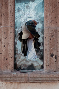 Rear view of woman looking through window