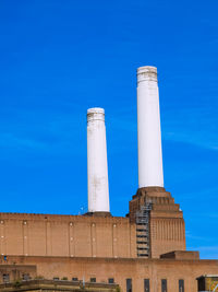 Low angle view of smoke stack against blue sky