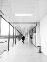 Rear view of people walking in airport building