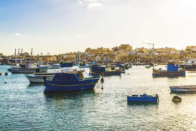 Boats in marina at harbor against sky