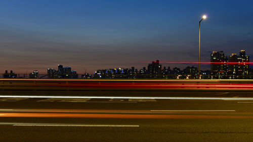 Light trails on road against sky at night