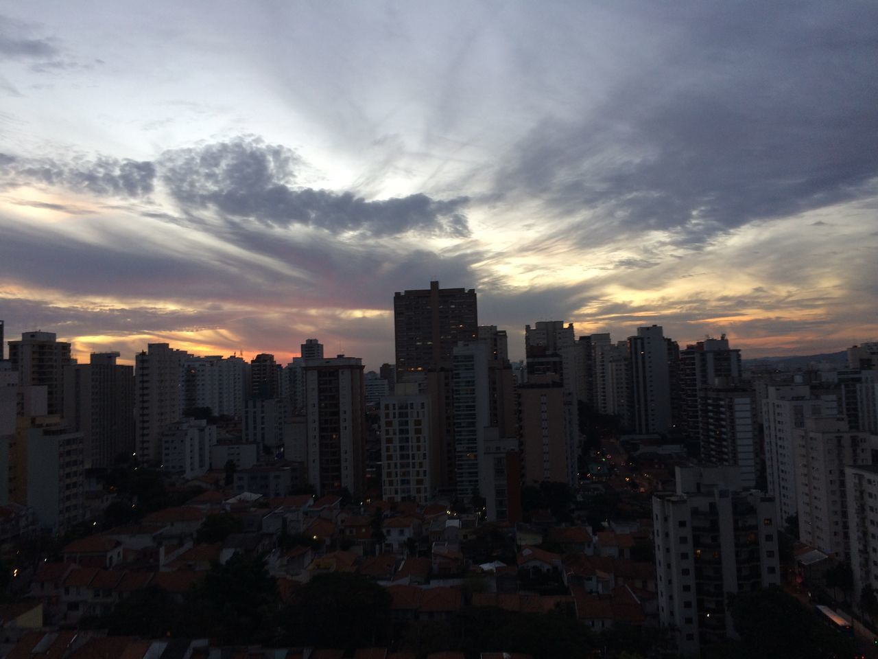 BUILDINGS IN CITY AGAINST SKY AT SUNSET