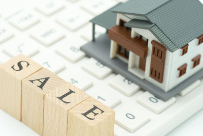 Close-up of model house on keyboard with text over table