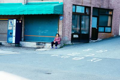 Rear view of man and woman standing against shutter