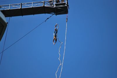 Low angle view of chain swing ride against clear sky