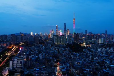 Illuminated modern buildings in city against sky