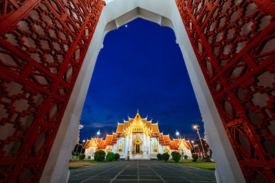 Illuminated buildings in city against sky