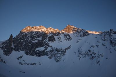 Scenic view of snowcapped mountains against clear blue sky