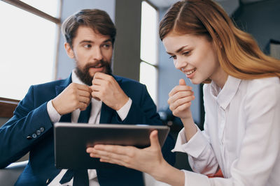 Young couple looking away while using smart phone