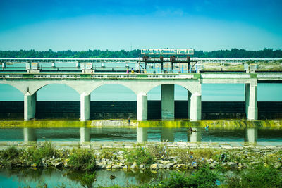 Arch bridge over river against sky