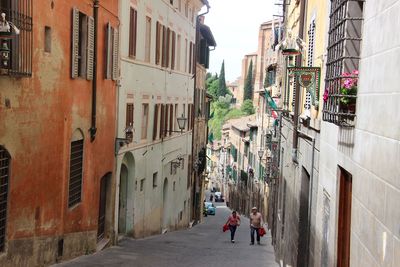 People walking on street amidst buildings in city