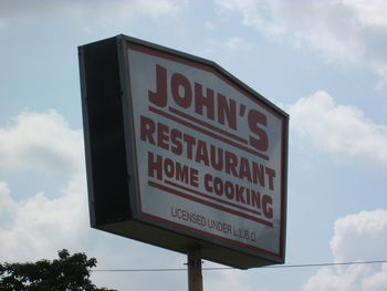 Low angle view of road sign against sky