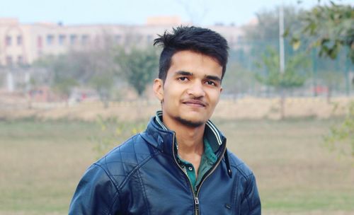 Close-up portrait of young man standing on field