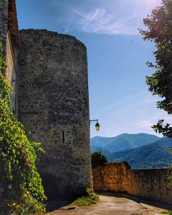 Stone wall of building against sky