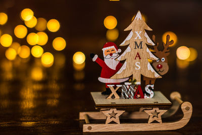 Close-up of illuminated christmas decoration on table at night