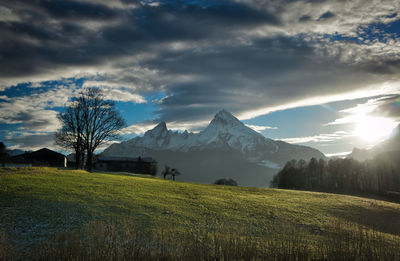 Scenic view of landscape and mountains against cloudy sky