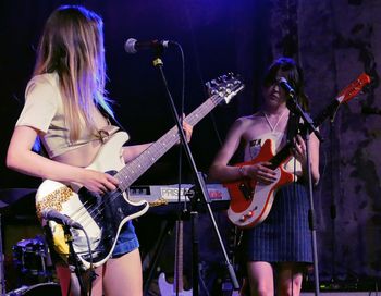 Woman playing guitar at music concert