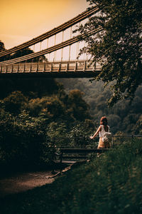 Woman standing on bridge against sky