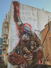 Low angle view of old statue against building in city