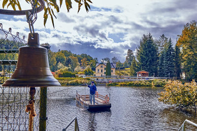 Rear view of man on boat against river