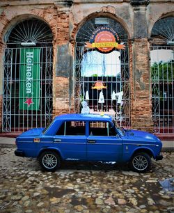 Vintage car on street against buildings in city