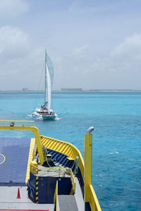 Catamaran with many tourists sails near a transport ferry in the mexican caribbean sea