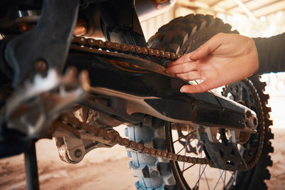 Cropped hand of man repairing bicycle