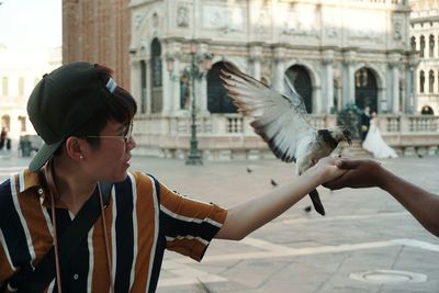 Woman feeding pigeon outdoors