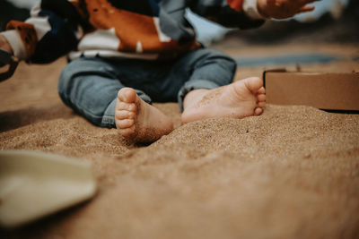 Baby feet that is playing with toys in the sand on the beach