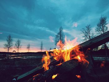 Bonfire on landscape against sky