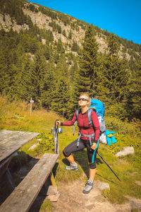 Full length of woman standing on mountain during sunny day