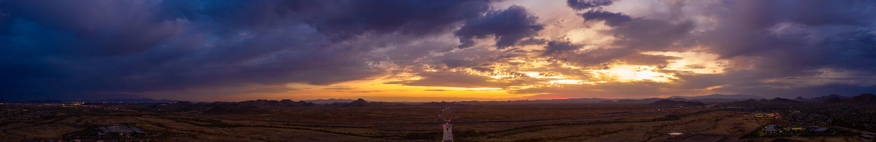 Panoramic view of landscape against dramatic sky during sunset