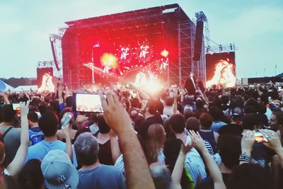 Crowd at music concert against sky