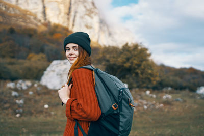 Side view of smiling young woman standing outdoors