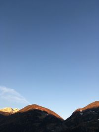 Low angle view of mountains against clear blue sky