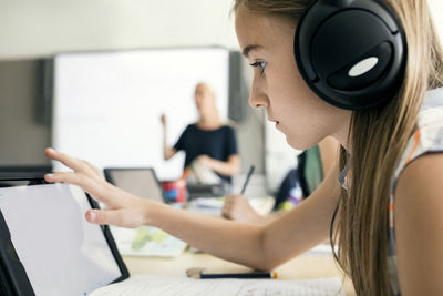 Side view of girl using digital tablet at school