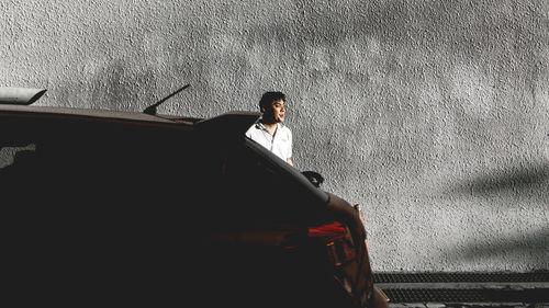 Young woman standing on car