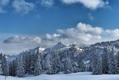 Scenic view of snow covered mountains against sky