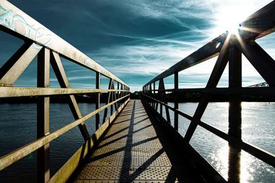 Bridge over calm sea against sky