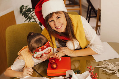 A happy family mother and child pack christmas gifts. new year gifts. homemade christmas presents.