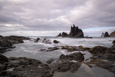 Rocks on beach against sky